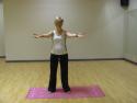 Upright and arms reaching out in the yoga warm up