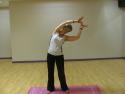 A student in a yoga class in Cardiff using the Four Elements warm up and bending to the right